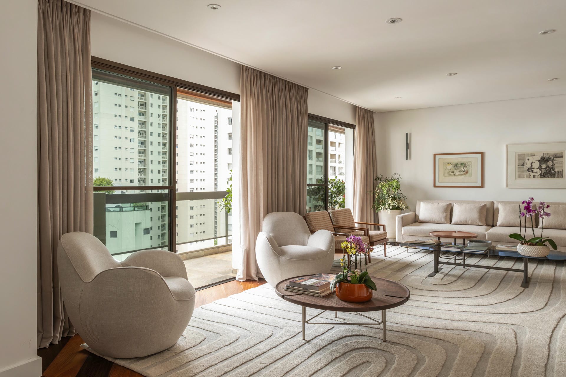 Sala do Apartamento Castel Verona, com poltronas claras, cortinas do piso ao teto e vista da cidade